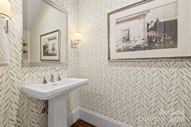 bathroom featuring wallpapered walls and a sink