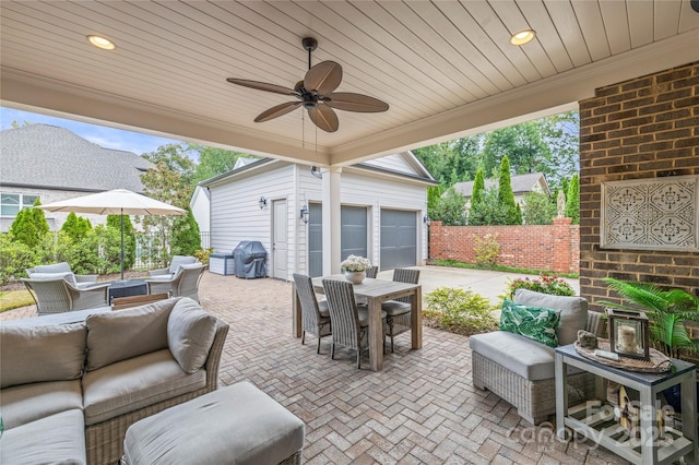 view of patio featuring outdoor dining area, an outdoor hangout area, a garage, fence, and a ceiling fan