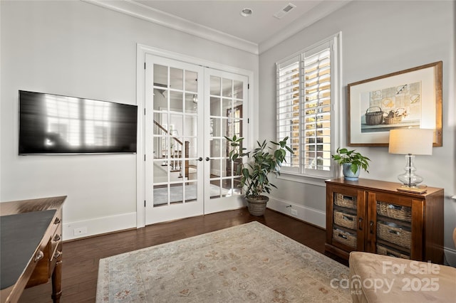 living area featuring wood finished floors, visible vents, baseboards, french doors, and ornamental molding