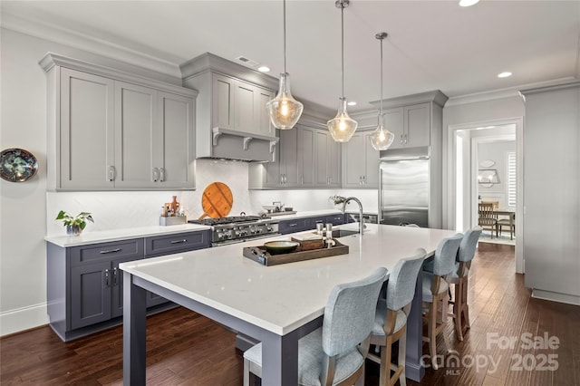 kitchen featuring high quality appliances, gray cabinets, a sink, and light countertops