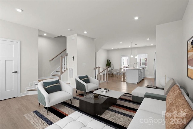 living room with light hardwood / wood-style floors and sink