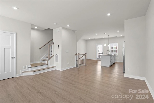 empty room featuring sink and light hardwood / wood-style flooring