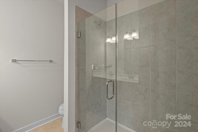 bathroom featuring walk in shower, tile patterned floors, and toilet