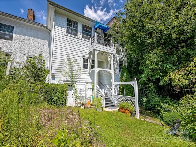 view of front of home featuring a front yard and a balcony