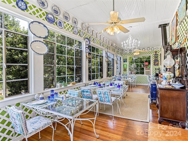 sunroom / solarium with ceiling fan with notable chandelier