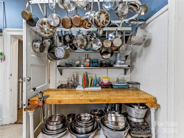 interior space with tile patterned flooring, butcher block counters, and tile walls