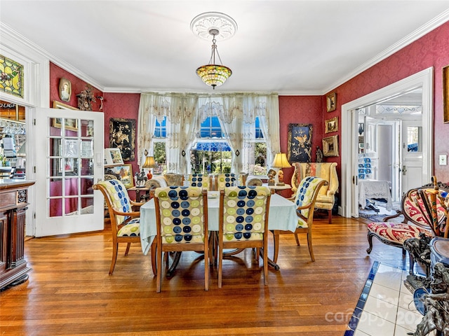 dining space featuring hardwood / wood-style floors and crown molding