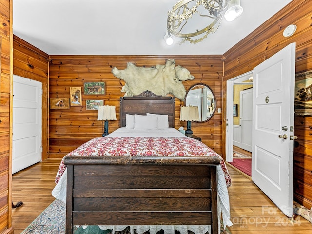 bedroom featuring light hardwood / wood-style flooring and wood walls