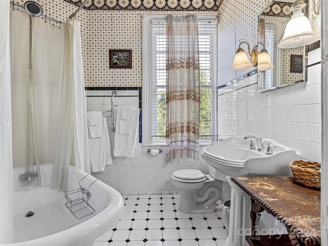 bathroom featuring separate shower and tub, toilet, and tile walls