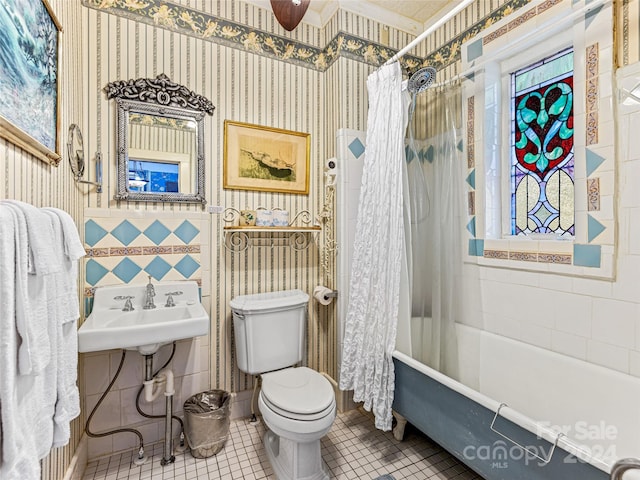 full bathroom featuring tile patterned floors, sink, toilet, tile walls, and shower / tub combo with curtain