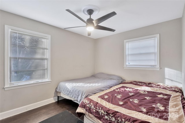 bedroom with dark hardwood / wood-style floors and ceiling fan