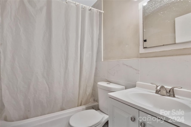 full bathroom with toilet, vanity, shower / tub combo with curtain, and tile walls