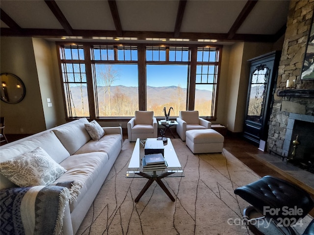 living room with beam ceiling, a mountain view, a fireplace, and carpet