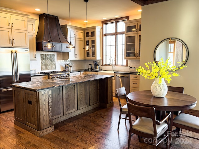 kitchen featuring a healthy amount of sunlight, dark hardwood / wood-style flooring, a kitchen island, and stainless steel appliances