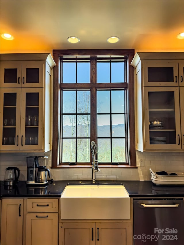 kitchen featuring stainless steel dishwasher, backsplash, and sink