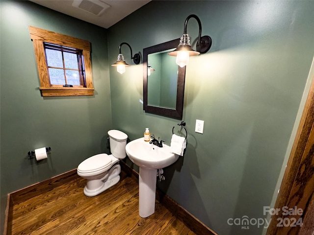 bathroom with hardwood / wood-style floors and toilet