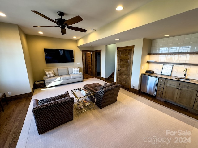 living room featuring ceiling fan, light hardwood / wood-style floors, and indoor wet bar