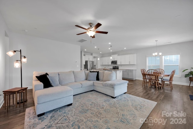 living room with wood-type flooring and ceiling fan with notable chandelier