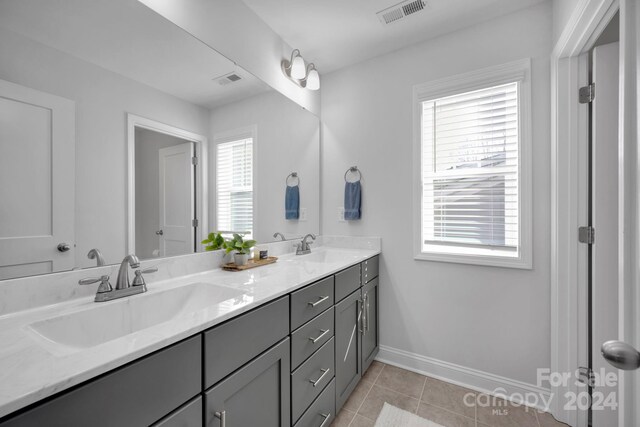 bathroom with tile patterned flooring, vanity, and a wealth of natural light