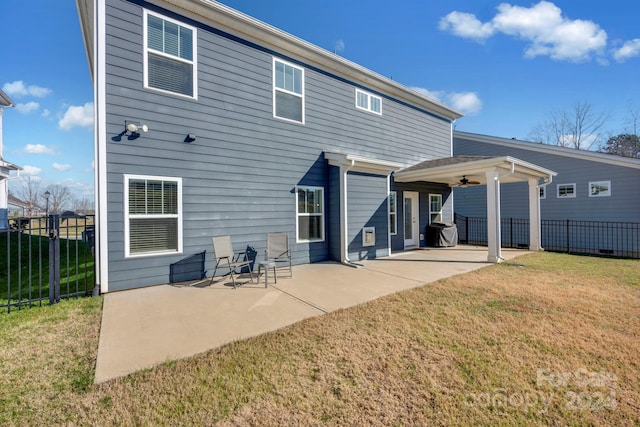 back of property with a lawn, a patio area, and ceiling fan