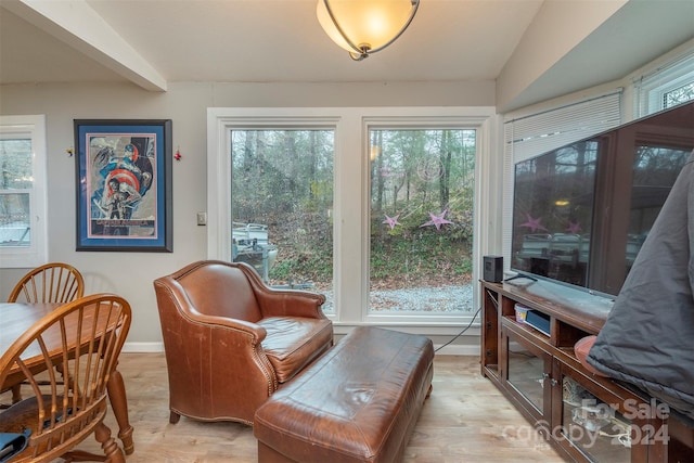 sitting room with plenty of natural light, lofted ceiling, and light hardwood / wood-style flooring