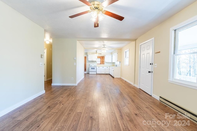 unfurnished living room featuring ceiling fan, baseboard heating, and light hardwood / wood-style flooring