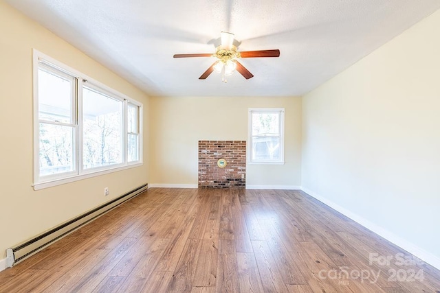 unfurnished living room with ceiling fan, a baseboard radiator, and light wood-type flooring