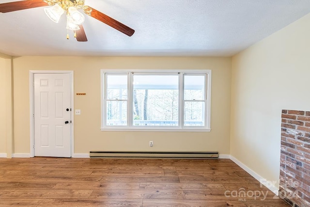 foyer entrance featuring a textured ceiling, ceiling fan, wood-type flooring, and a baseboard radiator