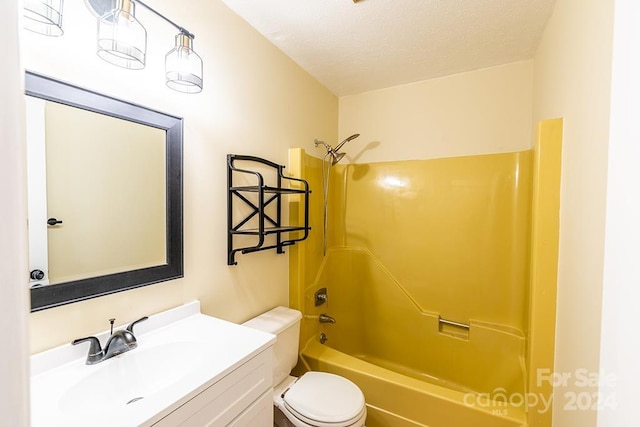 full bathroom with a textured ceiling, vanity,  shower combination, and toilet