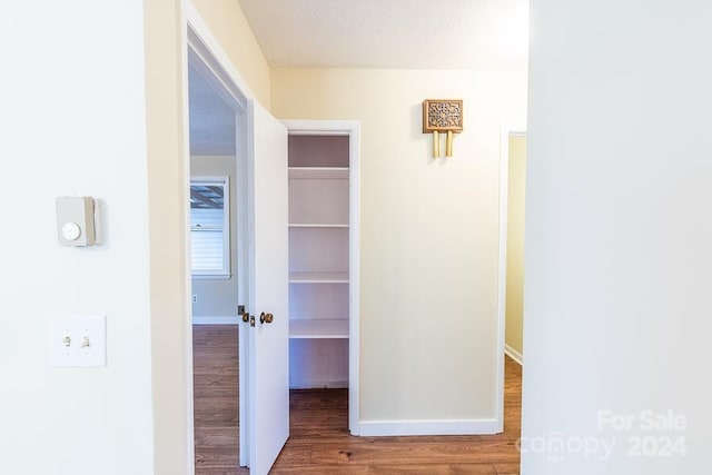 hall featuring a textured ceiling and hardwood / wood-style flooring