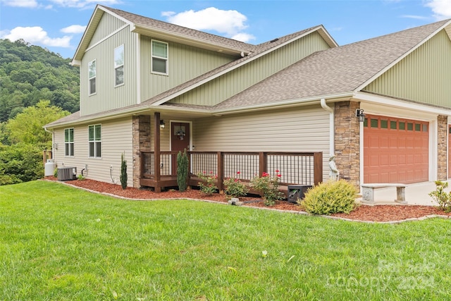 front of property with central air condition unit, a front yard, and a deck