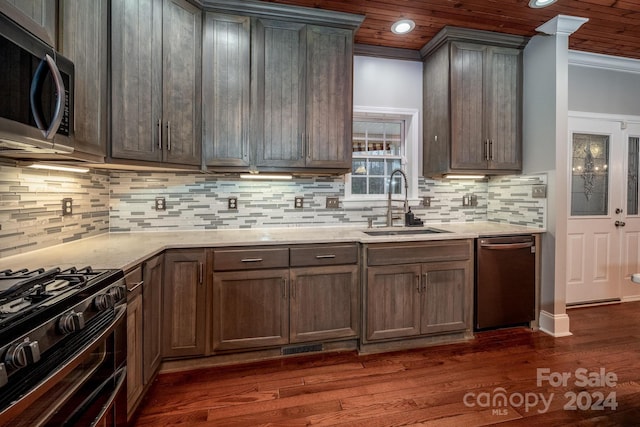 kitchen featuring dark hardwood / wood-style flooring, stainless steel appliances, tasteful backsplash, and sink