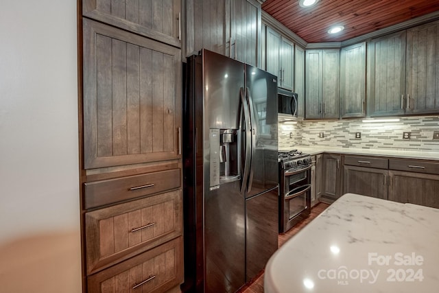 kitchen with decorative backsplash, light stone counters, wood ceiling, stainless steel appliances, and dark wood-type flooring