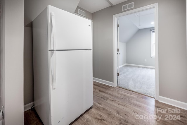 kitchen featuring lofted ceiling, white fridge, and light hardwood / wood-style floors