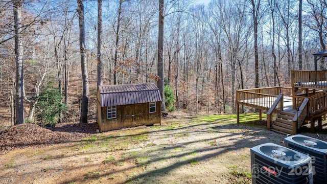 view of yard with a wooden deck, cooling unit, and a shed