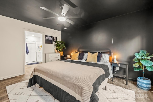 bedroom featuring ceiling fan, light hardwood / wood-style floors, and ensuite bathroom