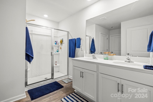 bathroom with hardwood / wood-style floors, vanity, and walk in shower