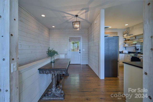 doorway to outside with wooden walls and dark wood-type flooring