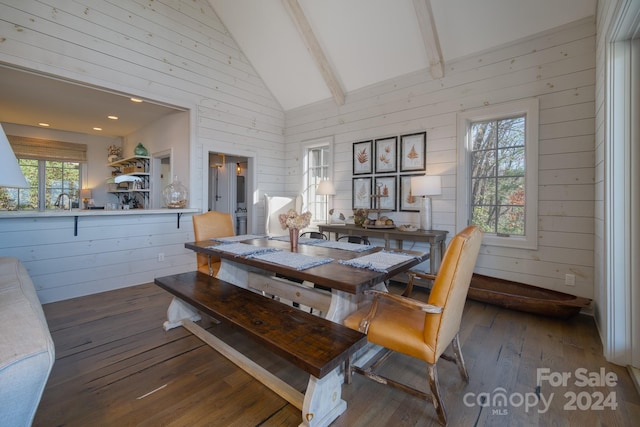 dining area with wooden walls, dark hardwood / wood-style floors, beam ceiling, and high vaulted ceiling