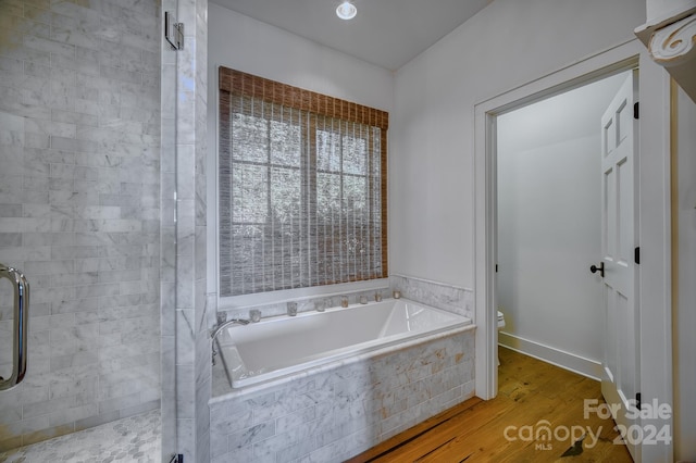 bathroom with wood-type flooring, toilet, and independent shower and bath