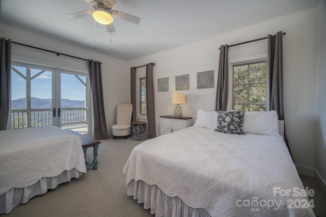 bedroom with carpet, a mountain view, ceiling fan, and access to outside