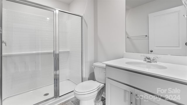 bathroom with walk in shower, vanity, and toilet