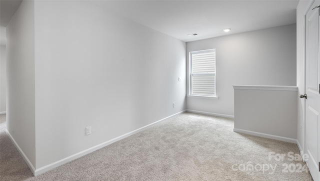 unfurnished room featuring light colored carpet