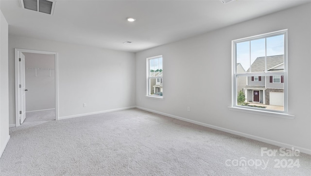 carpeted spare room featuring a healthy amount of sunlight