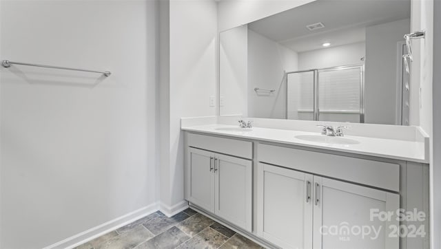 bathroom featuring vanity and a shower with shower door