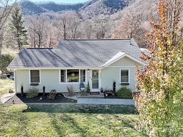 single story home featuring a mountain view and a front yard