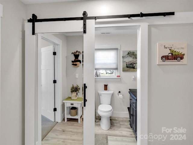 bathroom with hardwood / wood-style flooring, vanity, and toilet