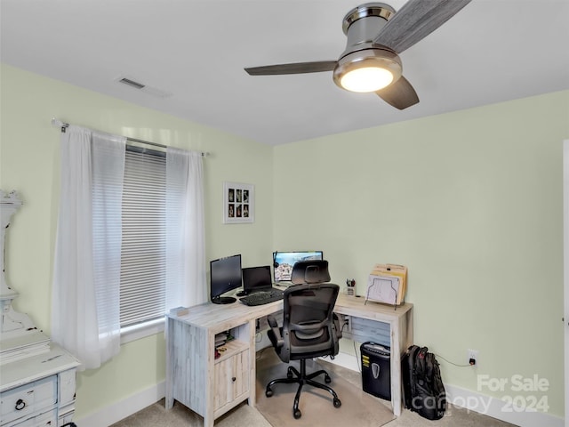 carpeted office space featuring ceiling fan