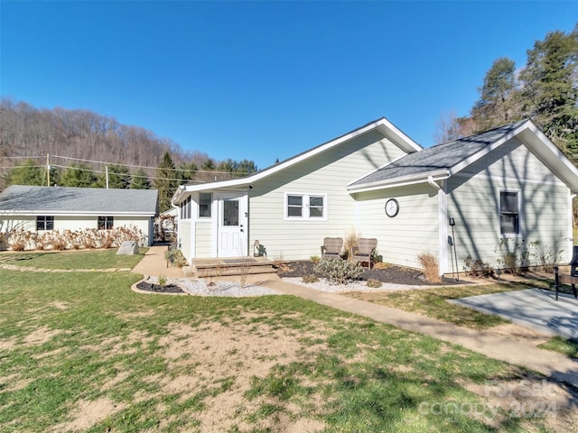 rear view of property featuring a lawn