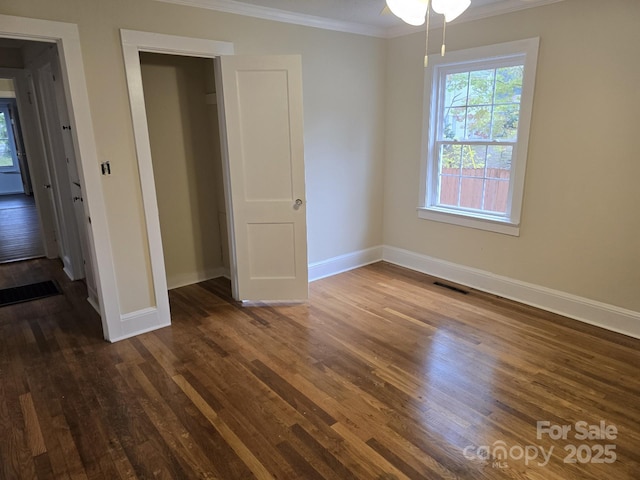 unfurnished bedroom with dark hardwood / wood-style flooring, a closet, and ornamental molding